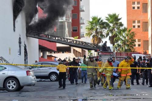 Red Cross personnel carry a body outside the Casino Royale in Monterrey, Mexico, Thursday. (AFP-Yonhap News)