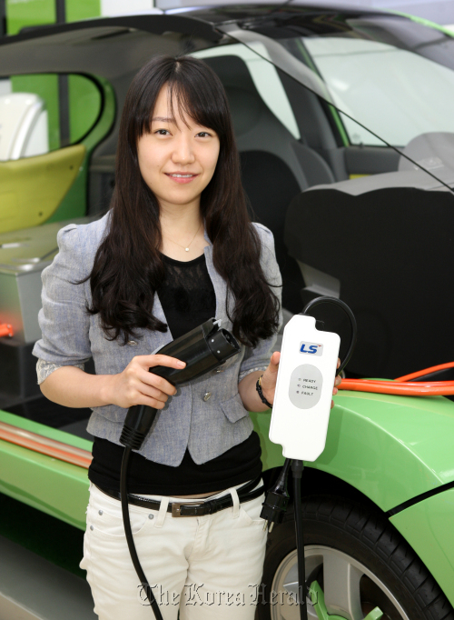 A model holds LS Cable and System’s electric vehicle charger on Monday. (LS Cable and System)