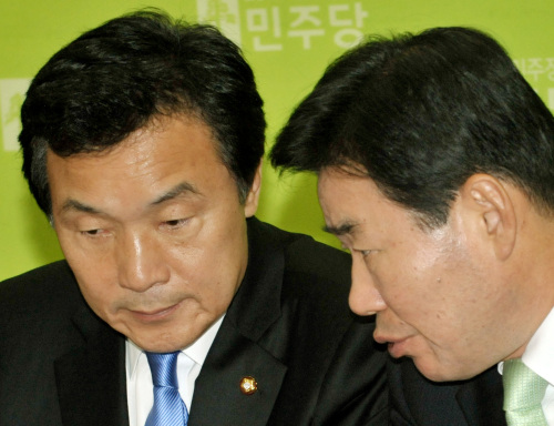 Democratic Party Chairman Sohn Hak-kyu (left, right photo) and floor leader Kim Jin-pyo exchange words in their parties’ respective Supreme Council meetings Monday. (Yang Dong-chul/The Korea Herald)