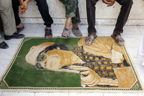 Libyan rebels put their foot in sign of disrespect on a carpet of Moammar Gadhafi used as a doormat in their camp set up in a district of sympathizers of Moammar Gadhafi in the stronghold city of Tarhouna, 100 kms south east of Tripoli, Libya, Monday. (AP-Yonhap News)