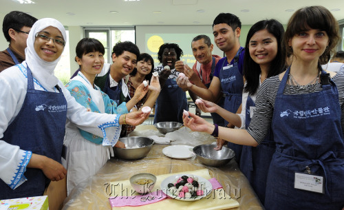 Foreigners of many nationalities participate in making songpyeon, or Korean rice cakes, on Thursday at the National Folk Museum of Korea as part of Chuseok preparations. (Park Hae-mook/The Korea Herald)