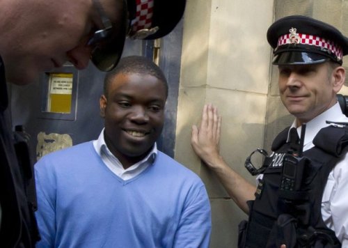 Alleged renegade UBS trader Kweku Adoboli, center, walks to be taken away in a security van flanked by police officers after appearing at the City of London Magistrates Court in London, Friday. (AP)