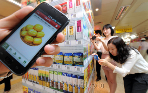 Customers buy products at a “virtual store” at Seolleung Station in Seoul using their smartphones. (Ahn Hoon/The Korea Herald)