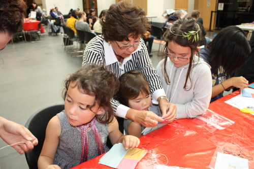 Mary Kim (center), a volunteer of Asian Art Museum of San Francisco, teaches young visitors how to make a piece of “bojagi,” traditional Korean patchwork, Saturday. (Claire Lee/The Korea Herald)