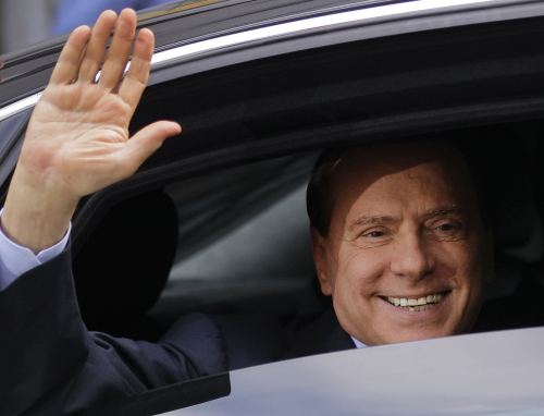 Silvio Berlusconi waves from his car in Milan’s tribunal, Italy, on Monday after attending a hearing. (AP-Yonhap News)