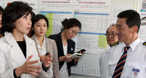 Rep. Na Kyung-won (left) of the Grand National Party talks with a driver in western Seoul on Thursday.  (Yonhap News)