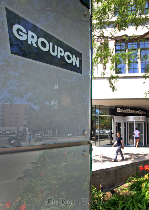 A pedestrian walks past Groupon Inc. signage displayed outside of company headquarters in Chicago, Illinois. (Bloomberg)