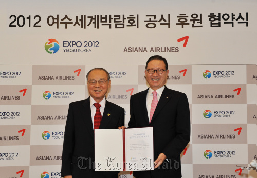 Asiana Airlines CEO Yoon Young-doo (right) and Organizing Committee for Expo 2012 Yeosu Korea chairman Kang Dong-suk pose after signing the sponsorship contract in Incheon International Airport on Sunday. (Asiana Airlines)