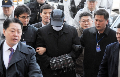 A criminal suspect is escourted by police. (Yonhap News)
