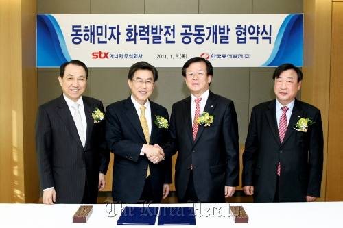 STX Group and Korea East-West Power Co. executives pose at the conglomerate’s office in Seoul after signing the deal for building the power plant in Donghae, Gangwon Province on Jan. 6. From left: STX Group chairman Kang Duk-soo, STX Energy CEO Lee Byung-ho, Korea East-West Power Co. CEO Lee Gil-gu and STX Energy and STX Heavy Industries chairman Lee Hee-beom. (STX Group)