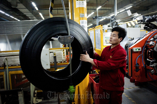 A factory worker produces tires at the Pirelli & C SpA tire factory in Jining, Shandong Province. (Bloomberg)