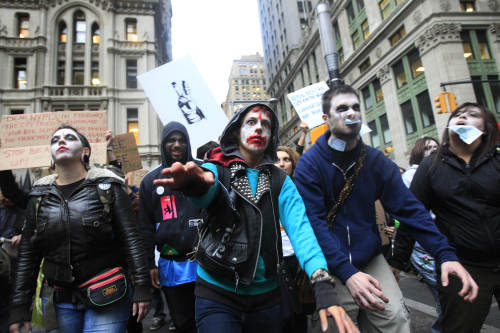 Protesters from Occupy Wall Street march down Broadway dressed as corporate zombies Monday in New York. The protests have gathered momentum and gained participants in recent days as news of mass arrests and a coordinated media campaign by the protestors have given rise to similar demonstrations around the country. (AP-Yonhap News)