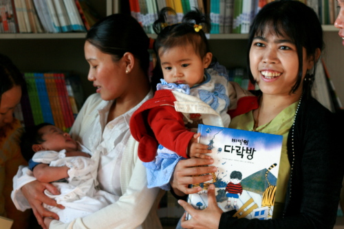Jumma mothers hold their children at the new Jum library in Yangchon, Gyeonggi Province. (Kirsty Taylor)