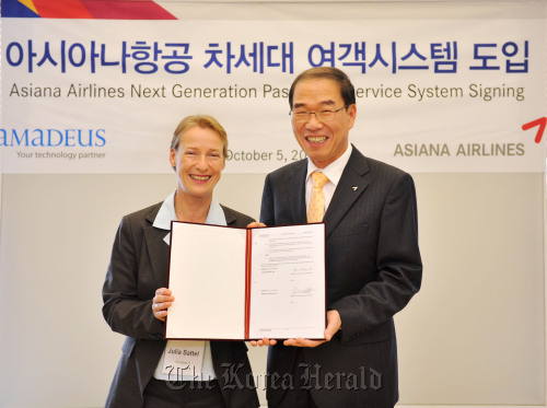 Chief of Asiana Airlines’s passenger business unit Ryu Kwang-hee (right) and Amadeus vice president Julia Sattel pose at the carrier’s headquarters in Seoul on Wednesday after signing an agreement to jointly develop automated travel management solutions. (Asiana Airlines)