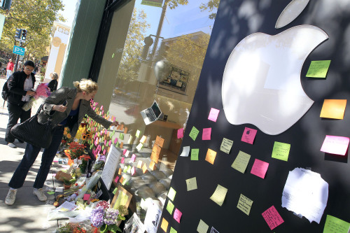 A woman leaves a post-it note at a memorial for Steve Jobs, outside an Apple store in Palo Alto, California. (Bloomberg)