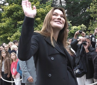France`s first lady Carla Bruni-Sarkozy waves in the gardens of the Elysee Palace in Paris. (AP)
