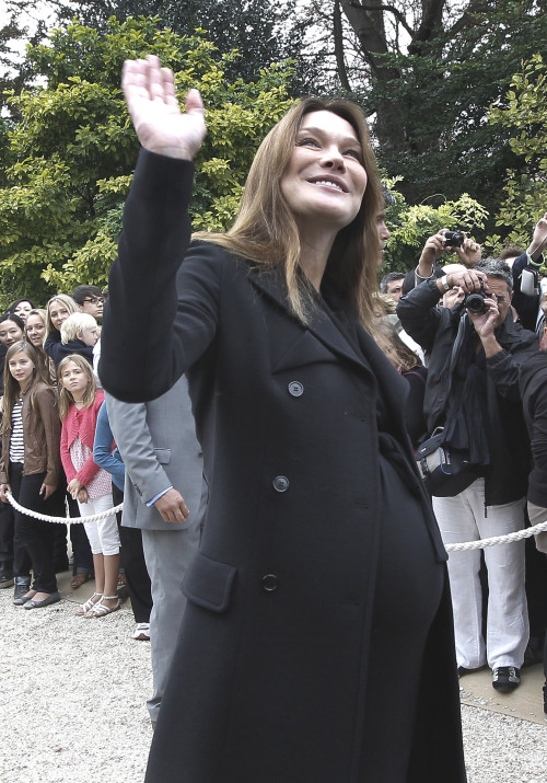 France’s first lady Carla Bruni-Sarkozy waves in the gardens of the Elysee Palace in Paris. (AP-Yonhap News)