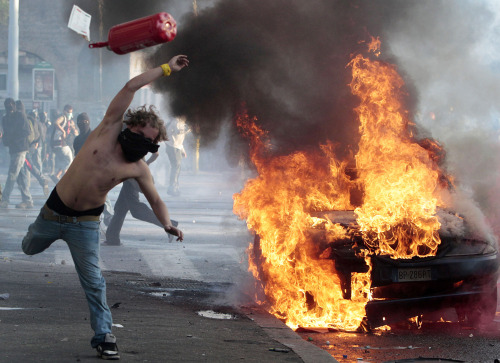 A protestor hurls a cannister clashes in Rome on Saturday. Protesters smashed the windows of shops in Rome and torched a car as violence broke out during a demonstration in the Italian capital, part of worlwide protests against corporate greed and austerity measures. (AP-Yonhap News)