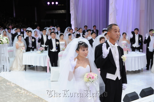 Multicultural and North Korean defector couples exchange vows during their group wedding at the KBS Hall in Seoul, Monday. (KBS)