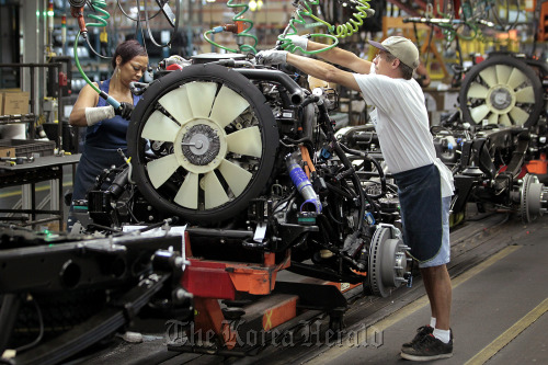 General Motors Co. employees work on the line at the company’s assembly plant in Flint, Michigan. (Bloomberg)