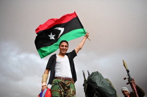 A Libyan fighter waves a flag outside a frontline hospital in the suburbs of Bani Walid, Libya on Monday. (Xinhua-Yonhap News)