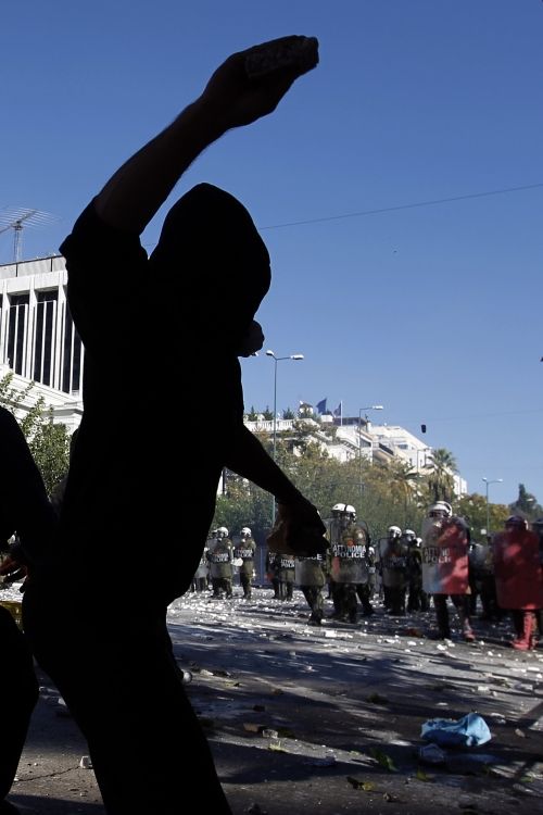 A protester throws a stone at Greek riot police, during clashes on Wednesday. (AP-Yonhap News)