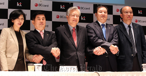 KT Corp. chairman Lee Suk-chae (center) and BC Card CEO Lee Jong-ho (second from right) pledge to converge information telecommunications and finance services at a meeting in downtown Seoul on Monday. (Yonhap News)