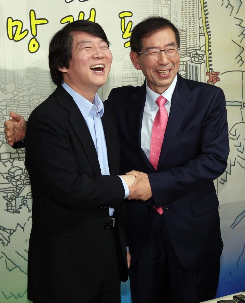 Ahn Cheol-soo (left) visits Park Won-soon’s campaign office on Monday. (Yonhap News)