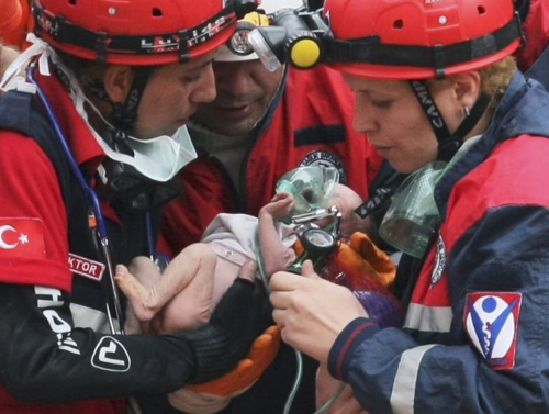 Turkish rescuers carry Azra Karaduman, a two-week-old baby girl they have saved from under debris of a collapsed building in Ercis, Van, eastern Turkey, Tuesday, Oct. 25, 2011. (AP)