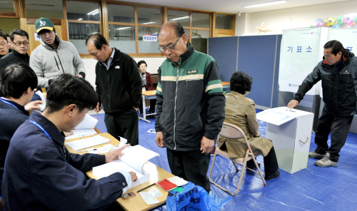 Voters at a polling station in northern Seoul prepare to cast ballots in the Seoul mayoral by-election on Wednesday morning. (Yang Dong-chul/The Korea Herald)