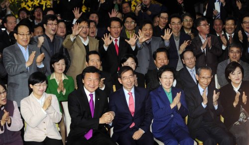 Members of the main opposition Democratic Party rejoice at independent candidate Park Won-soon’s campaign office in Seoul on Wednesday as the exit poll result shows him leading the race. (Yonhap News)