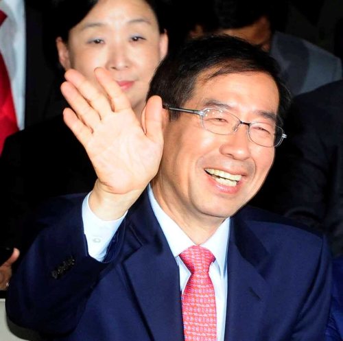 Independent candidate Park Won-soon celebrates at his campaign office in central Seoul on Wednesday as an exit poll shows him ahead of Na Kyung-won. (Yonhap News)