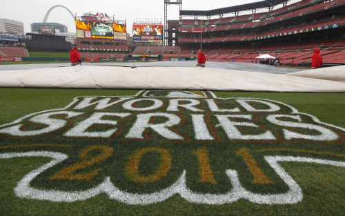 Workers remove a tarp from the infield at Busch Stadium in St. Louis on Wednesday, after officials announced that Game 6 of baseball’s World Series is postponed due to rain. (AP-Yonhap News)