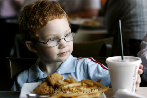 A child eats chicken strips and French fries. (MCT)