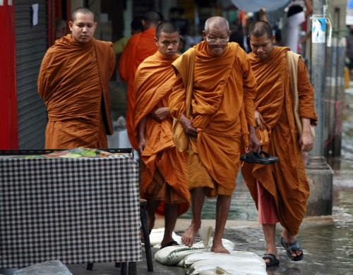 Buddhist monks make their way on a side walk of a flooded road near Mahathat temple in Bangkok, Thailand Wednesday, Oct. 26, 2011. Floodwaters inched closer to a terminal at the Thai capital's second largest airport Wednesday, leading many who had sought refuge at a shelter there to flee amid warnings that parts of Bangkok could be inundated by up to 5 feet (1.5 meters) of water. (AP-Yonhap News)