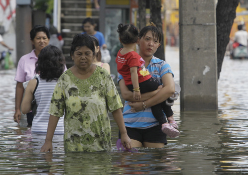 Thai residents wade through floodwaters in Bangkok, Thailand, Wednesday, Oct. 26, 2011. Floodwaters inched closer to a terminal at the Thai capital's second largest airport Wednesday, leading many who had sought refuge at a shelter there to flee amid warnings that parts of Bangkok could be inundated by up to 5 feet (1.5 meters) of water.(AP-Yonhap News)