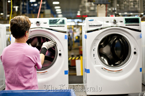 An employee installs a bellow to a front-load Whirlpool Corp. washing machine at the company’s operations plant in Clyde, Ohio. (Bloomberg)