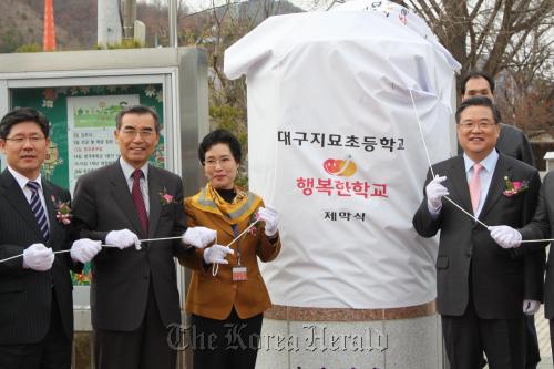 Chief of SK Group’s social enterprise project Shin Hun-cheol (second from left) takes part in the opening ceremony of an elementary school for the underprivileged children in Daegu in March. (SK Group)