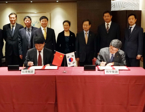 Hanwha Group and Yida Group officials including Hanwha China chief Keum Choon-soo (third from right, back row) look on as officials sign the MOU to collaborate on the resort project at a hotel in Hong Kong on Saturday. (Hanwha China)