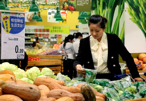 A shopper buys vegetables at a supermarket in Shanghai. (Xinhua-Yonhap News)