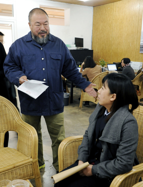Chinese artist Ai Weiwei, left, speaks to an official from the Beijing Local Taxation Bureau in his home in Beijing on Tuesday. (AP-Yonhap News)
