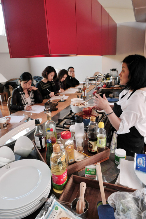 Attendees of the Pre-Wedding Course at Haedangwha focus on Suh Ji-hee’s cooking lesson last week. (Chung Hee-cho/The Korea Herald)