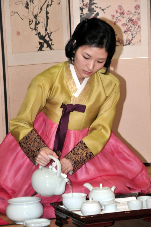 A young woman pours tea in front of the class during the maiden class graduation ceremony on Wednesday at Yejiwon in central Seoul. (Chung Hee-cho/The Korea Herald)