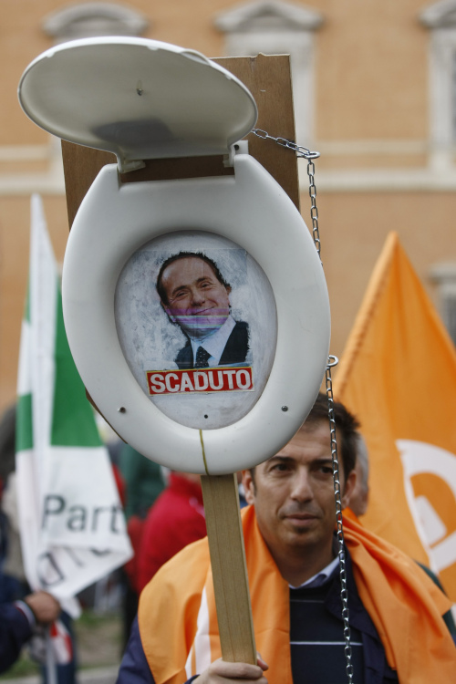A demonstrator holds a toilet seat with a picture of the Italian Premier Sivlio Berlusconi and writing which reads: 