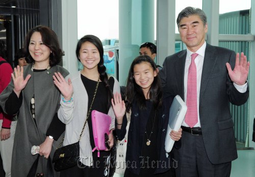 Sung Kim (right), the new U.S. ambassador to South Korea, waves to reporters along with his wife and two daughters upon arriving at Incheon International Airport on Thursday. (Kim Myung-sub/The Korea Herald)