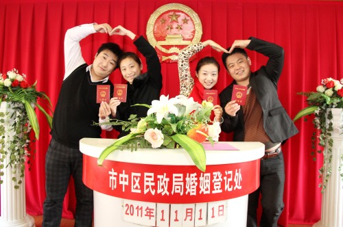 Two newly married couples show their marriage certificates at a register office in Zaozhuang, east China's Shandong Province, Nov. 11, 2011. (Xinhua-Yonhap News)