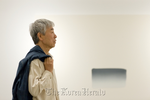 Lee Ufan with his work “Dialogue” on Monday at Gallery Hyundai in Sagan-dong, central Seoul. (Gallery Hyundai)