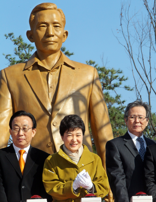 Rep. Park Geun-hye (center) of the ruling Grand National Party stands in front of the statue of her father, the late President Park Chung-hee, near his birthplace in Gumi, North Gyeongsang Province, Monday. The statue was unveiled in a ceremony marking his birth on Nov. 14. (Yonhap News)