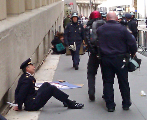 Retired Philadelphia Police Captain Ray Lewis, left, sits on the ground handcuffed after being arrested in New York near Wall Street during an Occupy Wall Street protest, Thursday. (AP-Yonhap News)