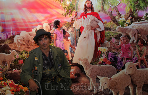 David LaChapelle poses in front of his work “Holy War” on Sunday at Seoul Arts Center’s Hangaram Design Center in Seocho-dong, southern Seoul. (Lee Sang-sub/The Korea Herald)